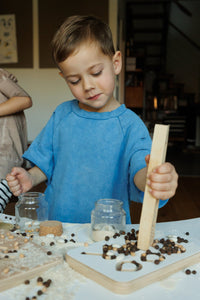 a boy playing good wood preschool wooden board