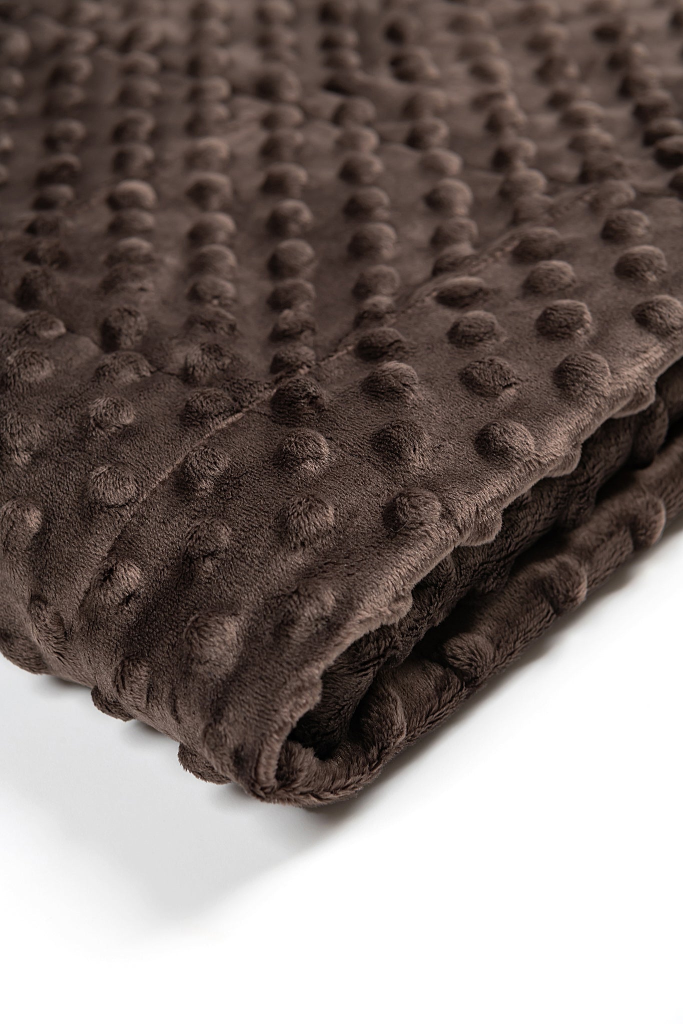 Folded brown textured blanket on a white background